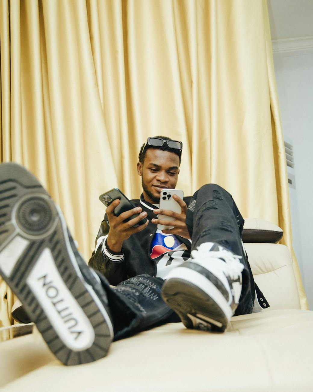 young man using latest mobile phones and wearing signatured sneakers