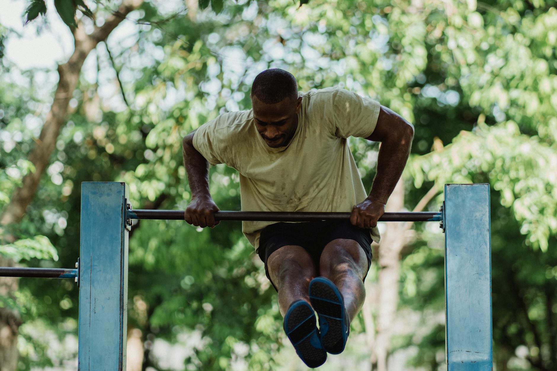 a man lifting himself over the pull up bar