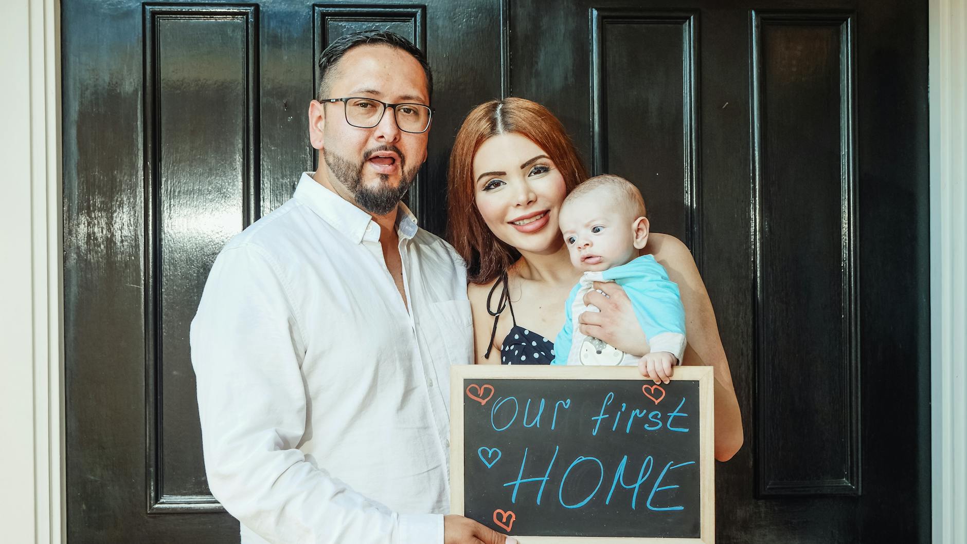 man in white dress shirt holding girl in white dress